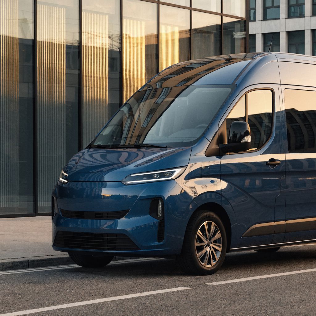 Blue van by a glass facade